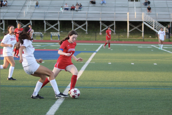 Junior Varsity sophomore captain Izzy Meyers rushes towards the goal past Justice defenders. “I had just gotten past the ball and was trying to get past one of the defenders. Luckily, I was able to get past them and almost scored. But sadly, we messed up at the end,” Meyers said.
